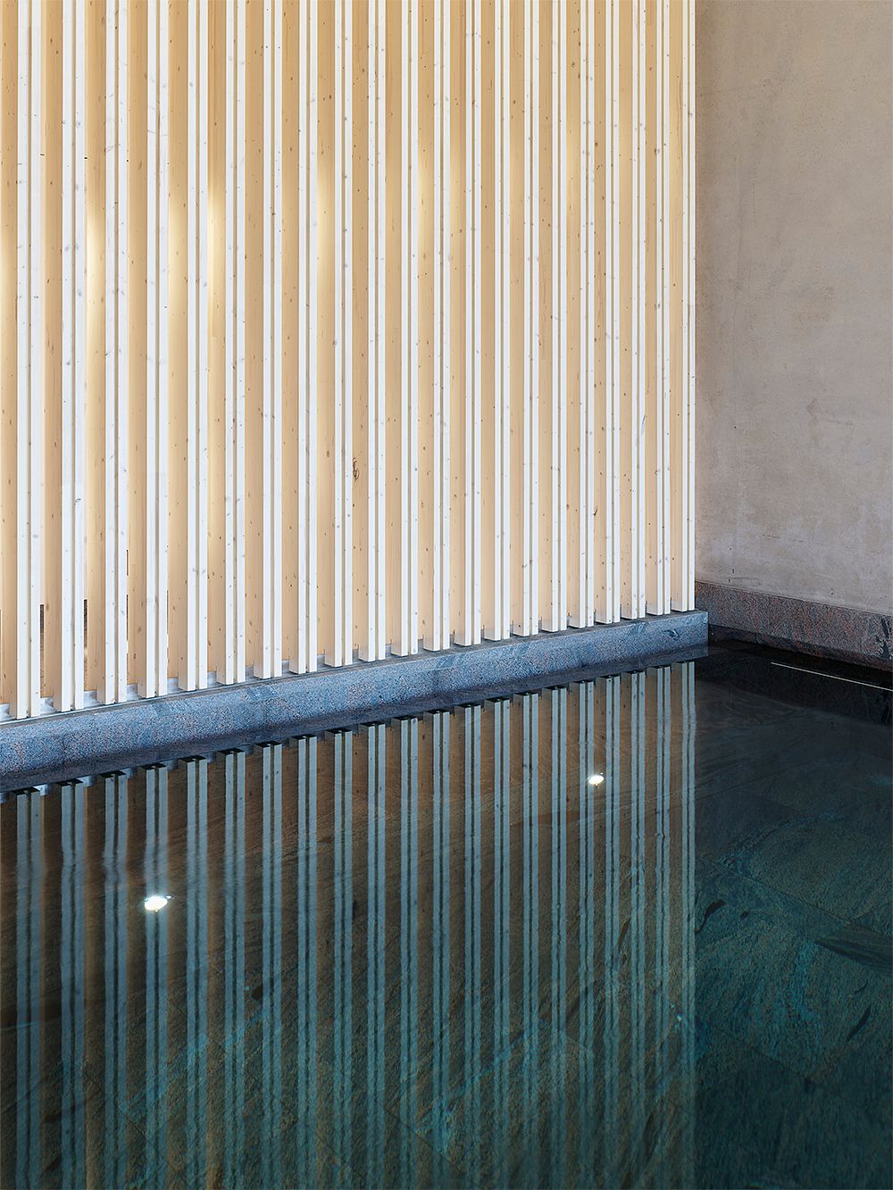 An image of Andrum spa's interior: a stone pool and wooden walls.