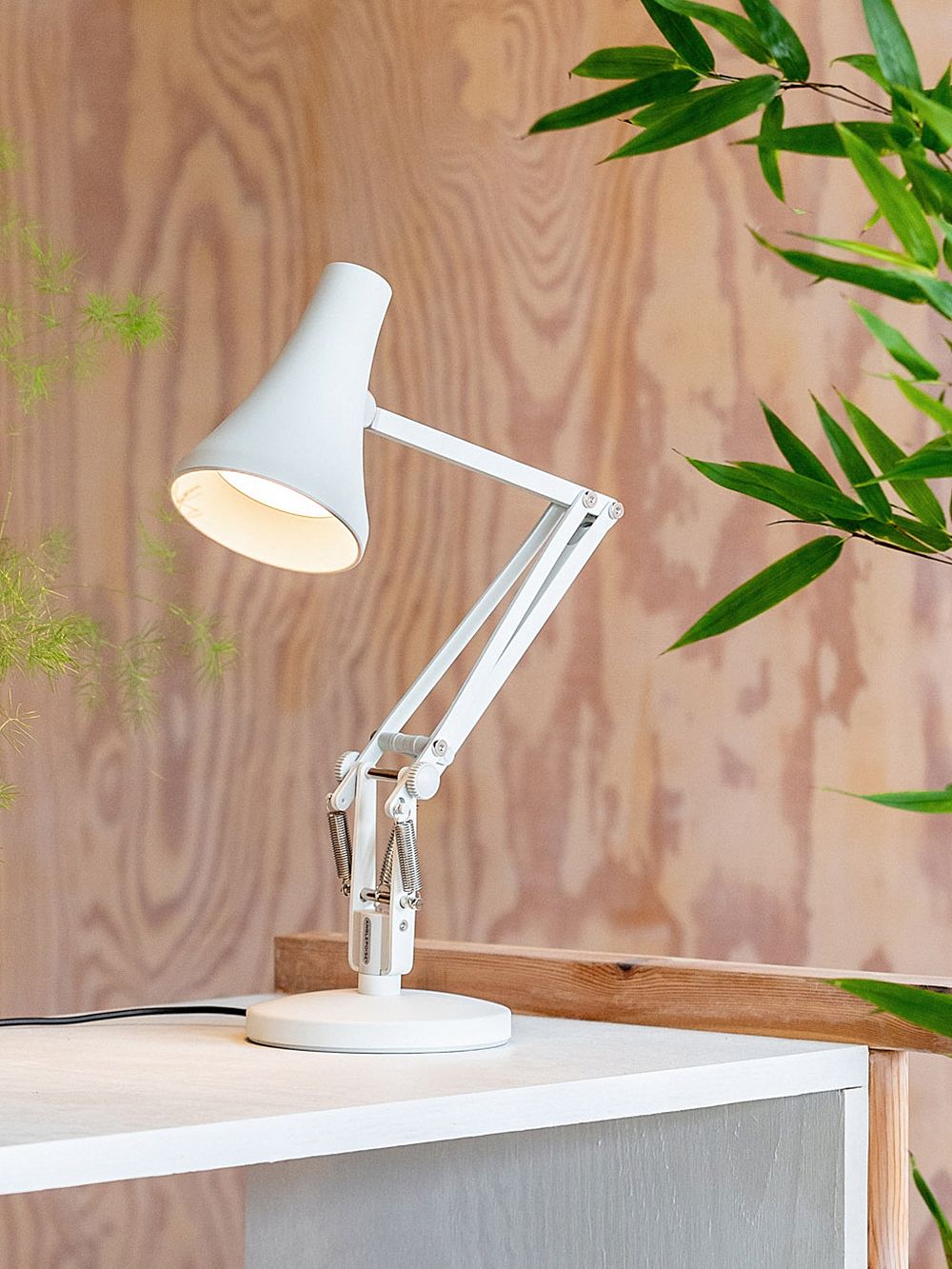 An image of Anglepoise's 90 Mini Mini table lamp in jasmine white on a table, as part of the home office decor.