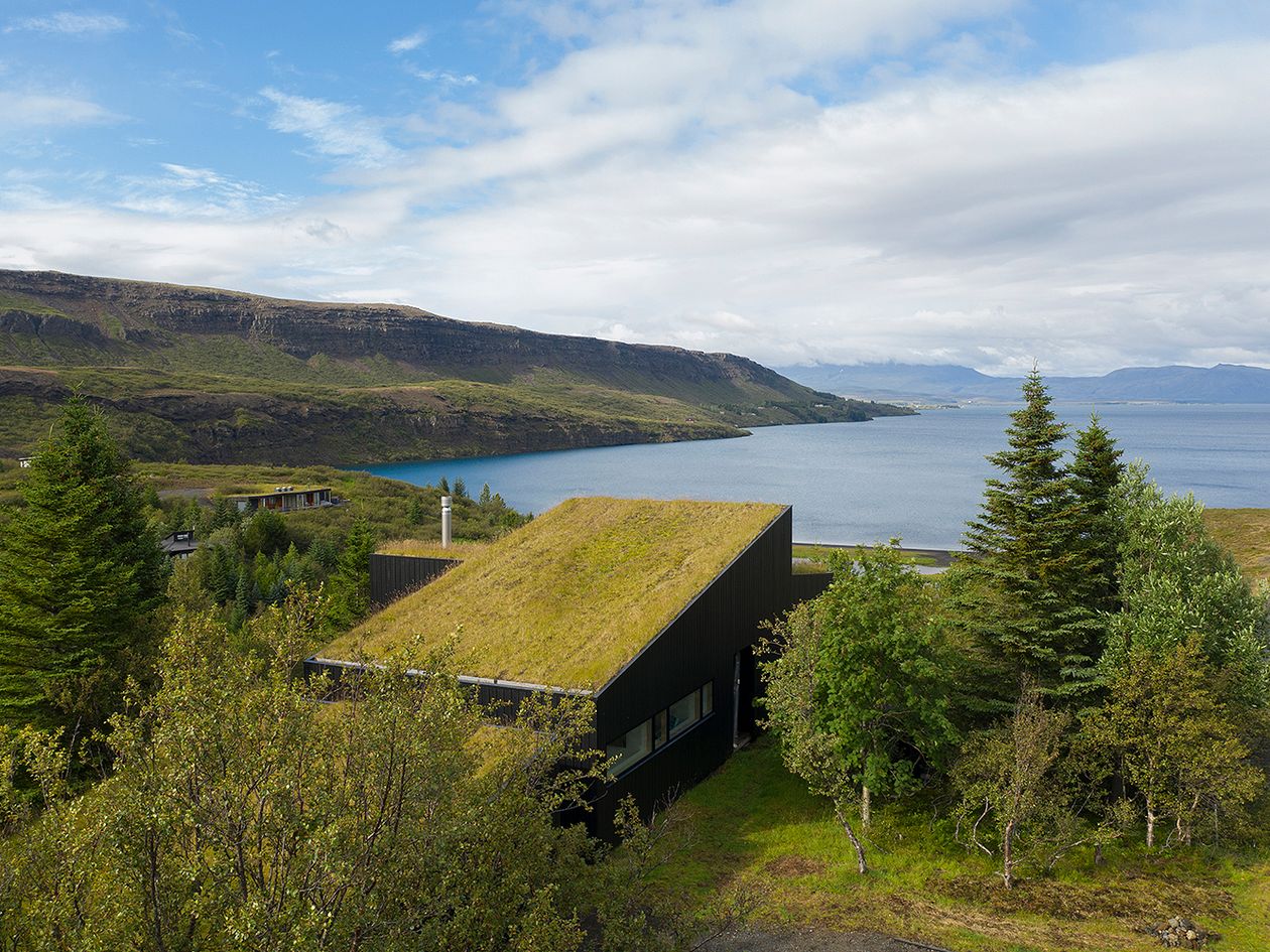 Kuva, jossa arkkitehtuuritoimisto KRADSin suunnittelema Holiday home by Þingvallavatn -rakennus. Kuvassa julkisivu ja ympäröivä, vuoristoinen maisema.
