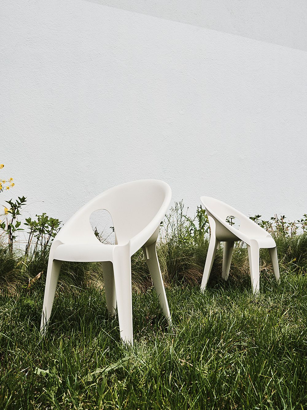 Kaksi valkoista Bell-tuolia ruohikossa
