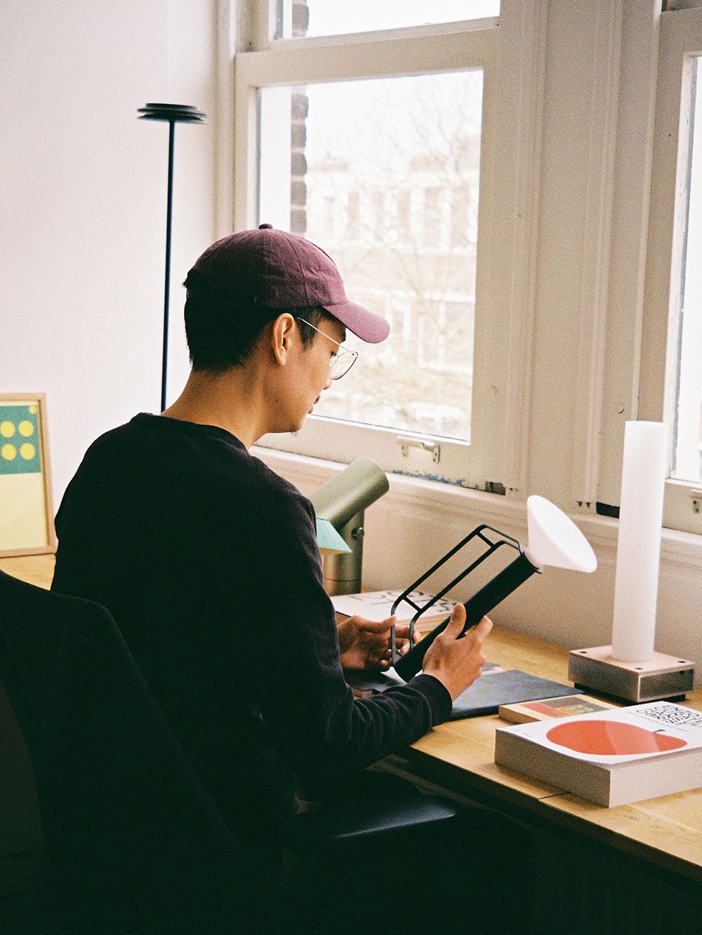 Kuva, jossa suunnittelija Tom Chung työpöytänsä ääressä kädessään Piton-valaisin.