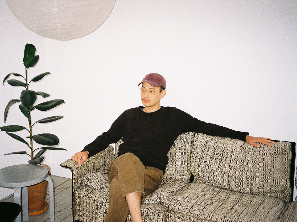 Kuva, jossa suunnittelija Tom Chung istuu sohvalla.
