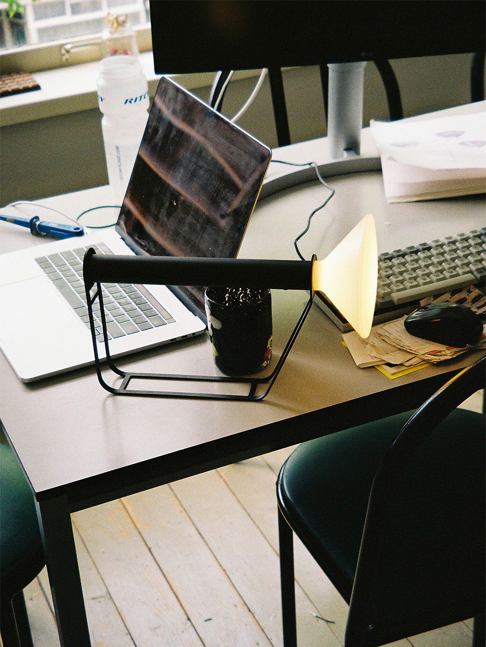 An image of a black Piton lamp as part of the home office decor.