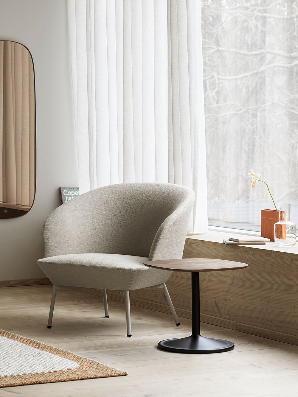 An image of Muuto's Oslo lounge chair and Soft side table as part of the living room decor.