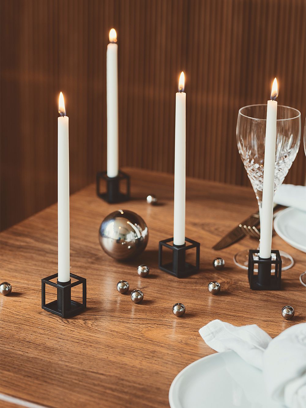 Kuva, jossa by Lassenin Kubus 1 -kynttilänjalkoja pöydällä, osana kattausta.
