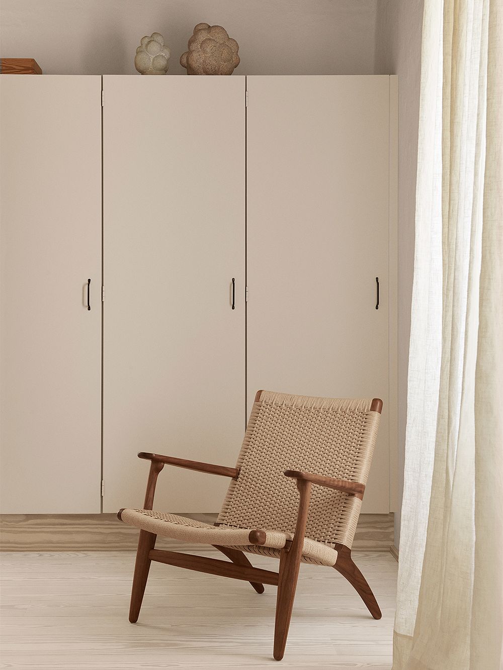 An image featuring Carl Hansen & Søn's CH25 armchair as part of the bedroom interior.