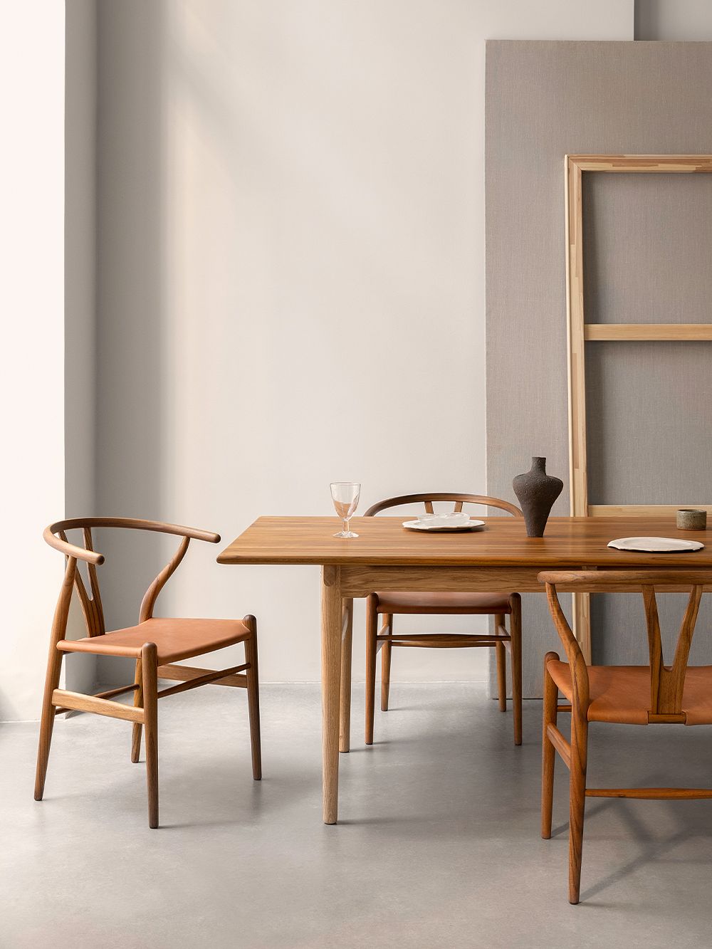 Kuva, jossa Carl Hansen & Sønin Wishbone-tuoleja pöydän ympärillä osana ruokailutilan sisustusta.