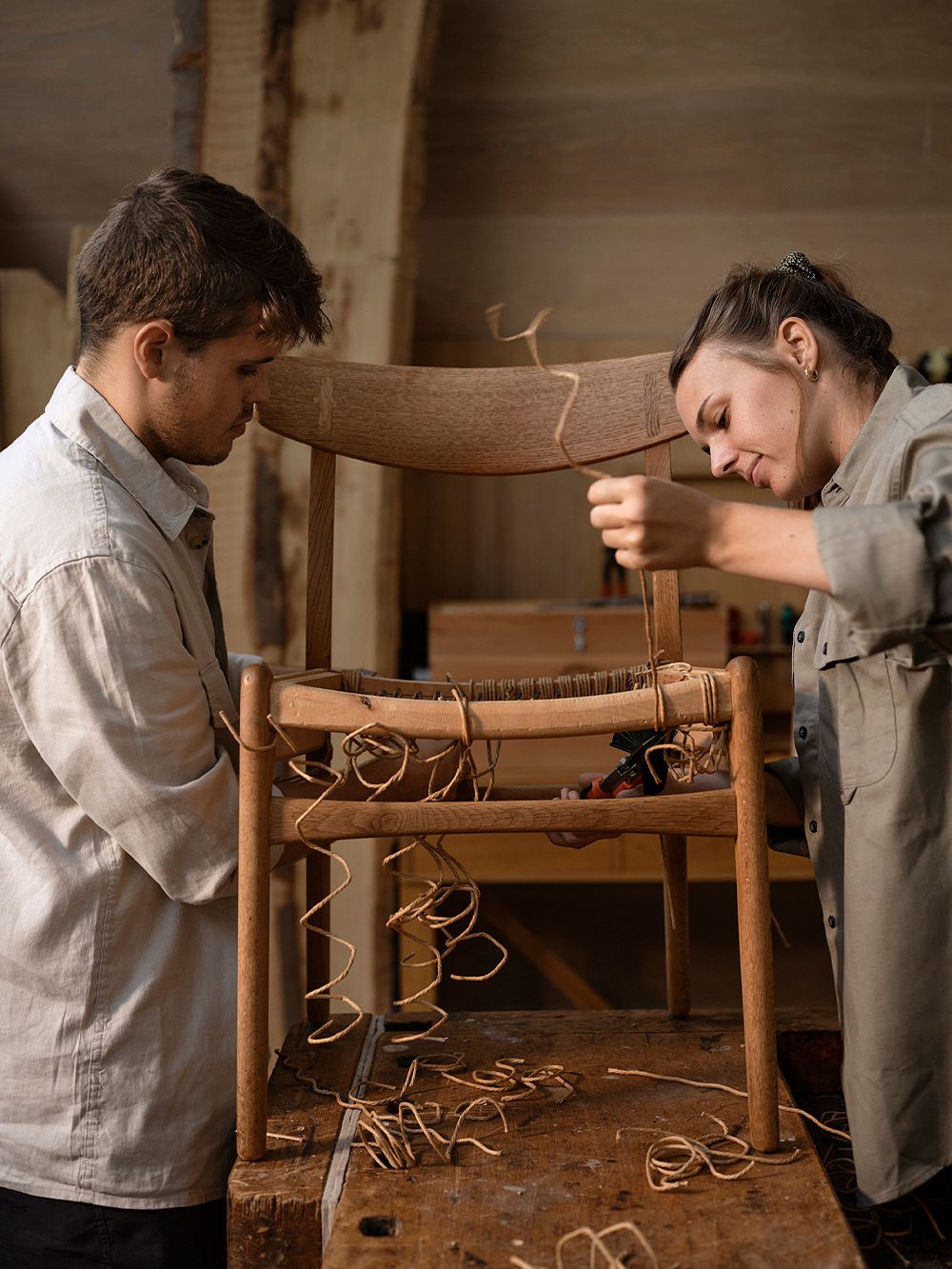 An image featuring of two people crafting Carl Hansen & Søn's CH23 chair by hand,