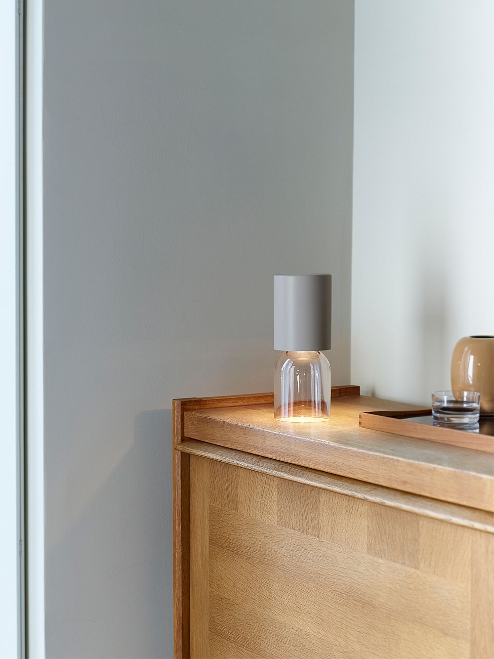 An image with Luceplan's Nut Mini table lamp on a sideboard, as part of the living room decor.