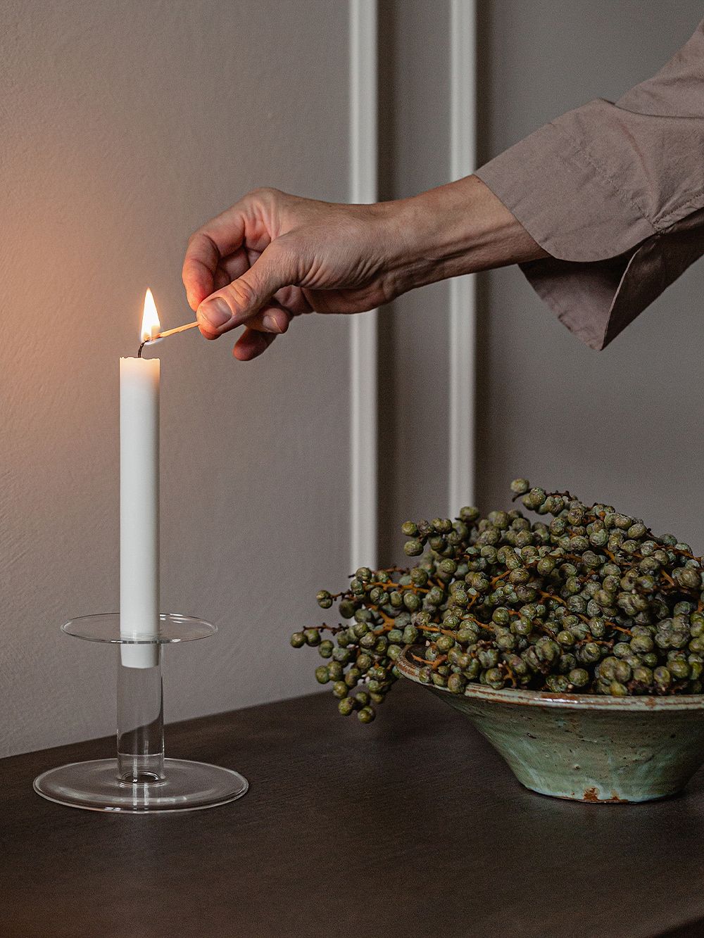 Kuva, jossa Menun lasinen Abacus-kynttilänjalka sivupöydällä, osana olohuoneen tai ruokailutilan sisustusta.