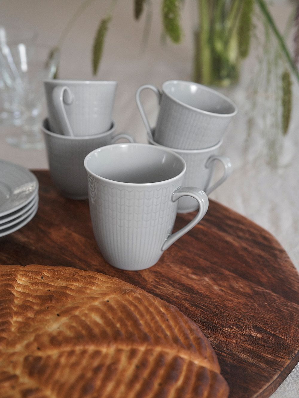 An image of Rörstrand's Swedish Grace plates and mugs in a table setting, as part of the dining room decor.