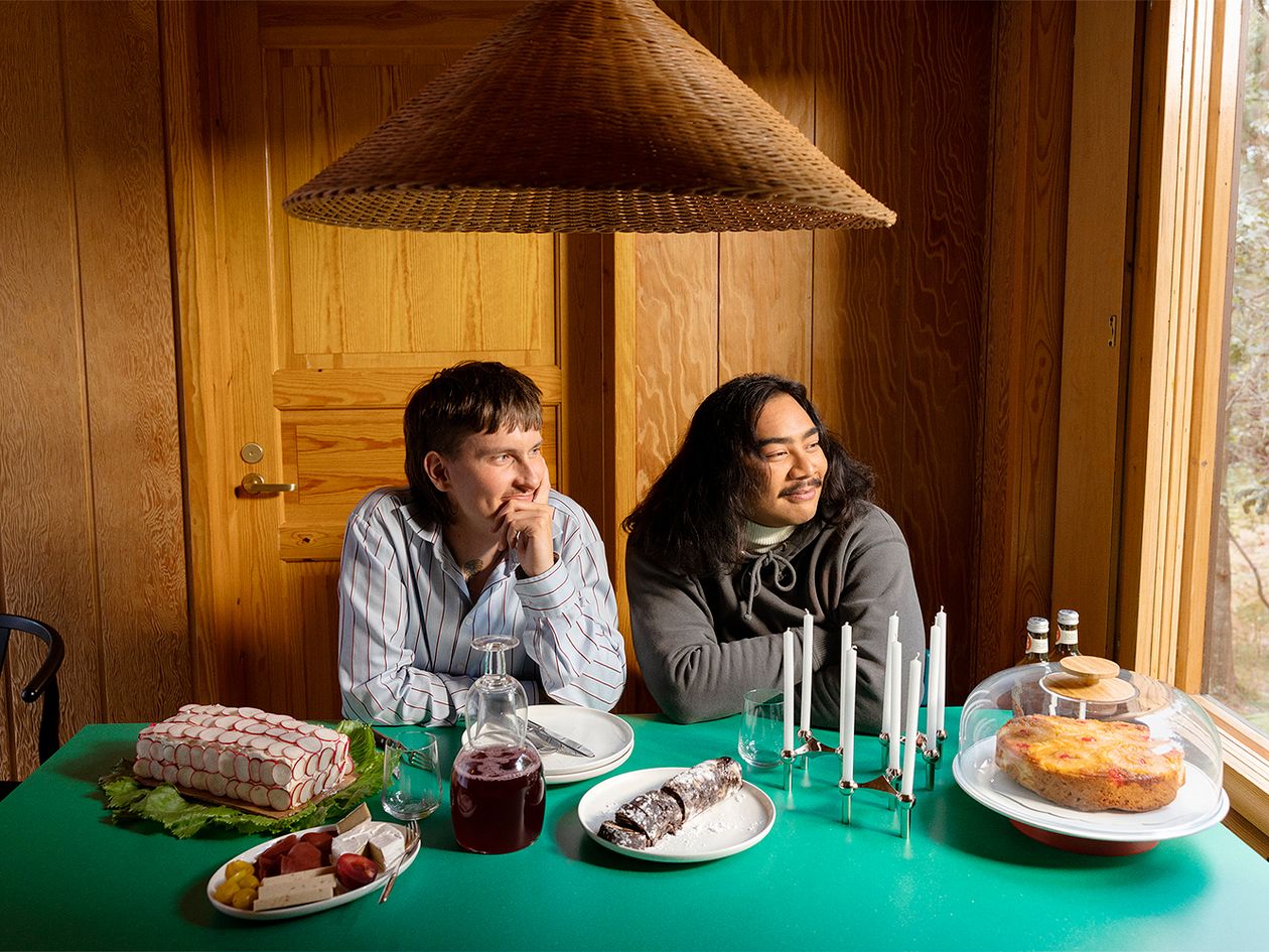 An image featuring two people sitting at a table. The decor and mood are laid-back but have a holiday-feel.