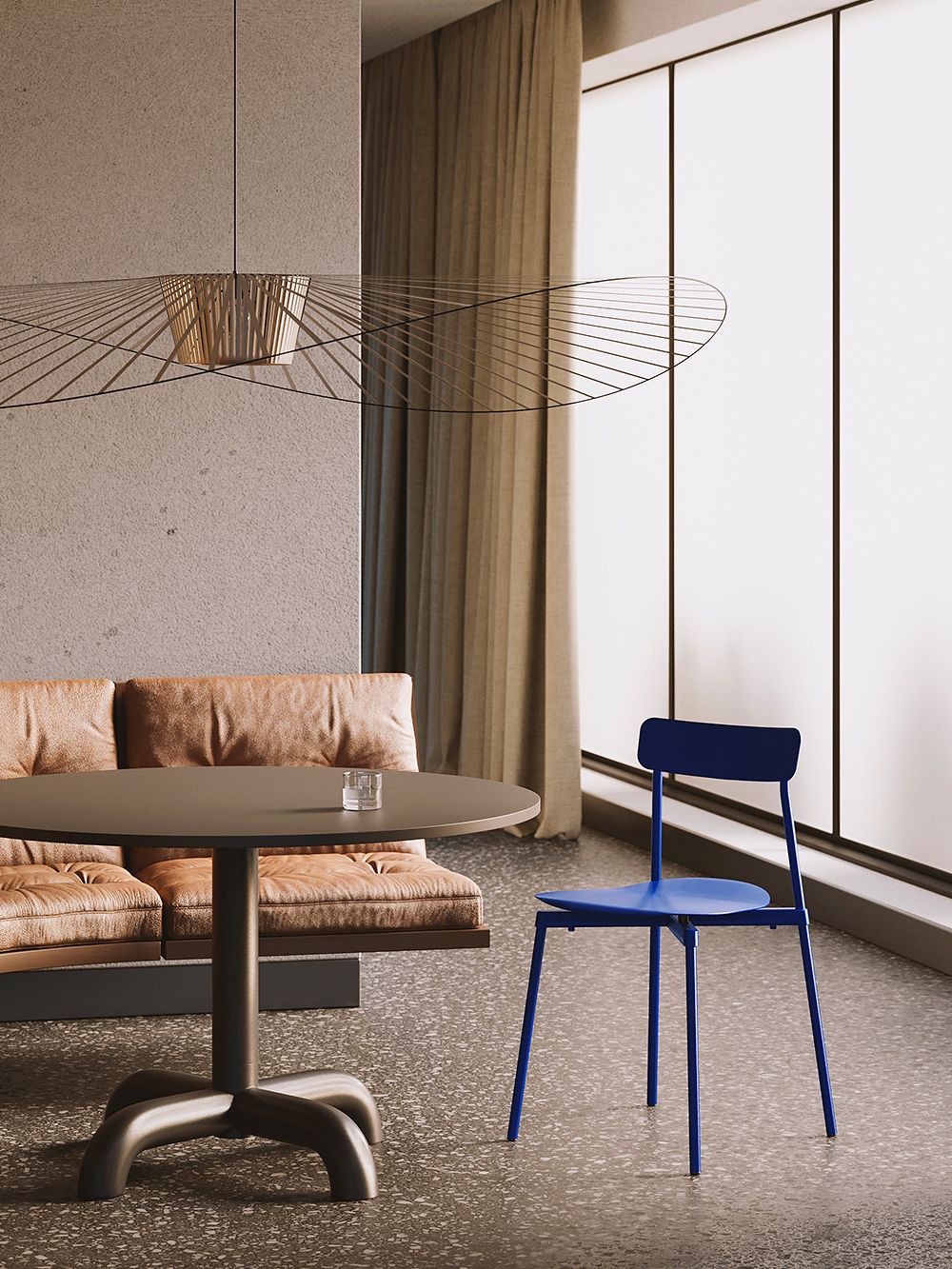An image of Petite Friture's blue Fromme chair at the table. Also shown is a Vertigo pendant light. 