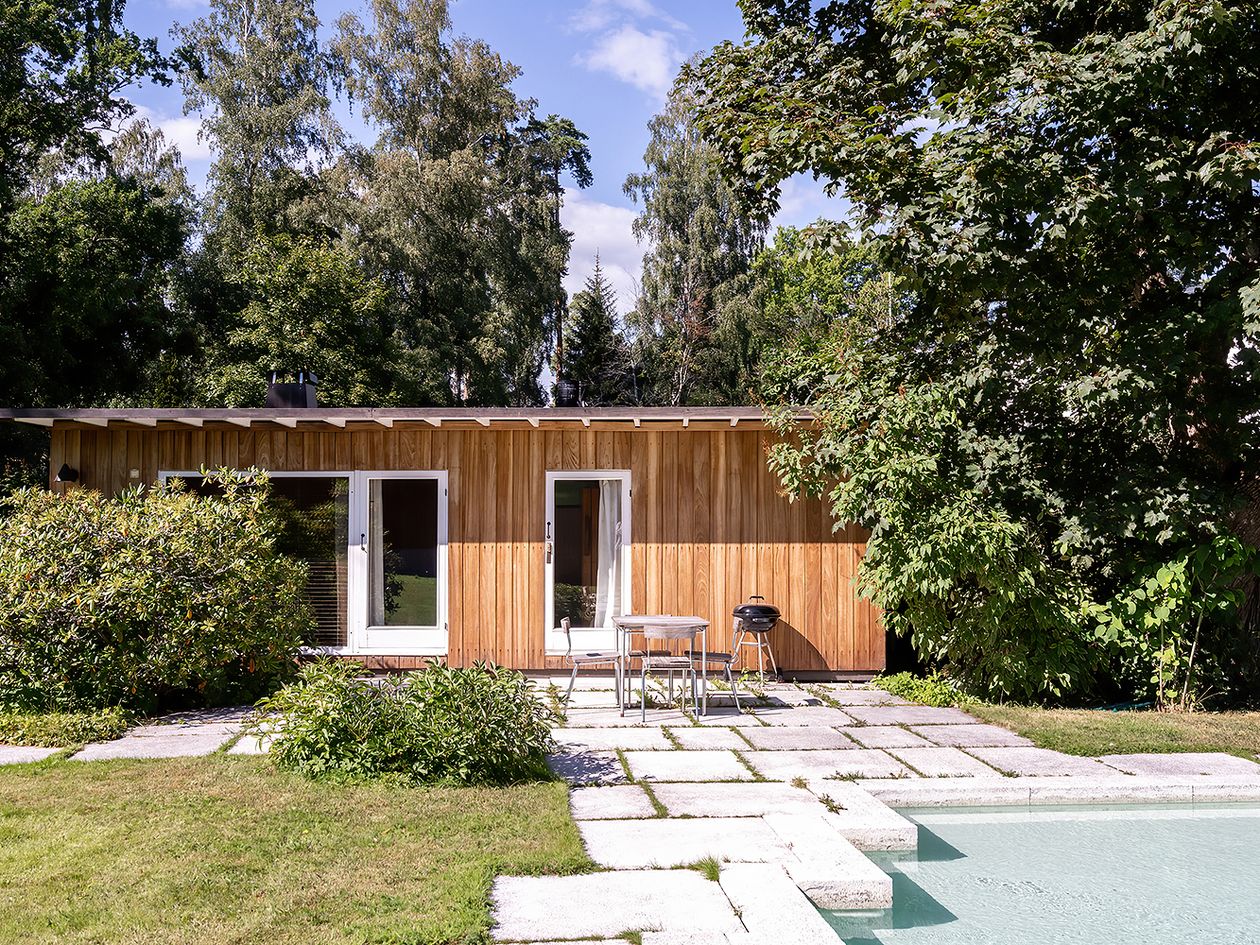 An image featuring Villa Ervi designed by architect Aarne Ervi. The photo shows the yard and the exterior of the sauna building.