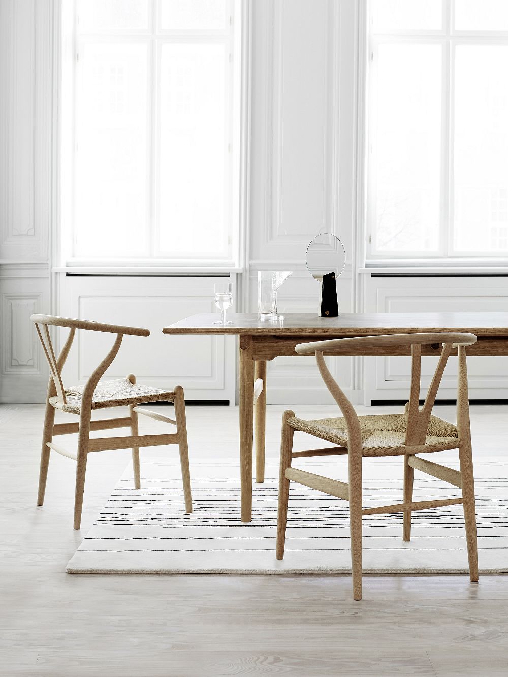 Carl Hansen & Søn's Wishbone chairs in soaped beech and natural paper cord, placed around a dining table