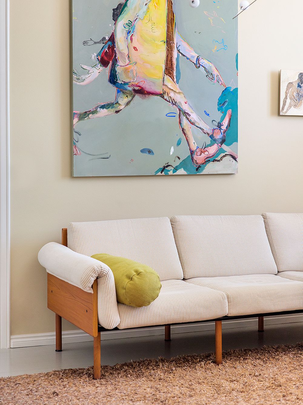 An image of the Ateljee sofa designed by Yrjö Kukkapuro, accompanied by a large painting on the wall.