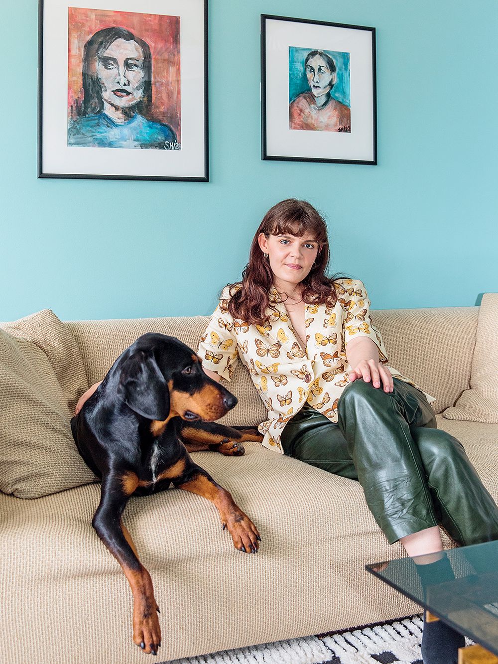 Iida Lappalainen istuu kotonaan sohvalla Kaapo-koiran kanssa