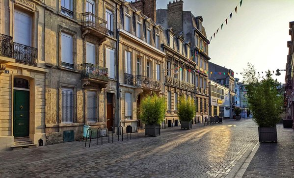 Une ruelle de Reims avec le soleil qui se lève sur la ville
