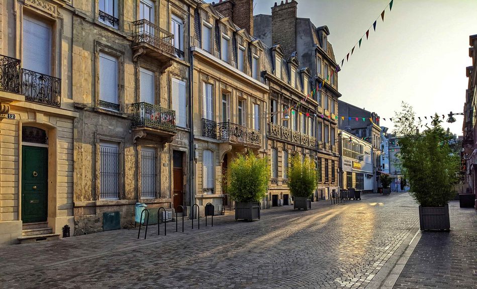 Une ruelle de Reims avec le soleil qui se lève sur la ville
