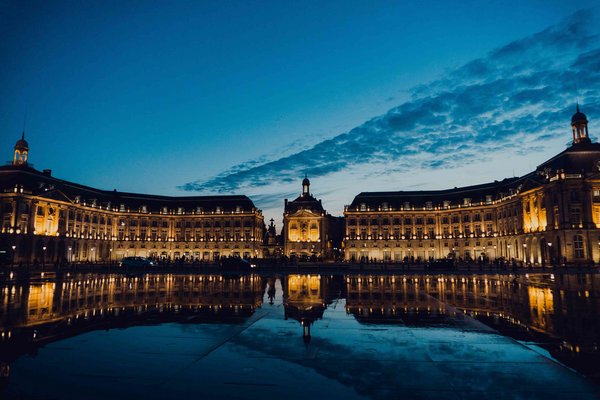 Place de la bourse à Bordeaux le soir avec la réflexion du bâtiment dans l'eau