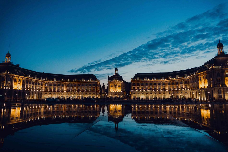 Place de la bourse à Bordeaux le soir avec la réflexion du bâtiment dans l'eau