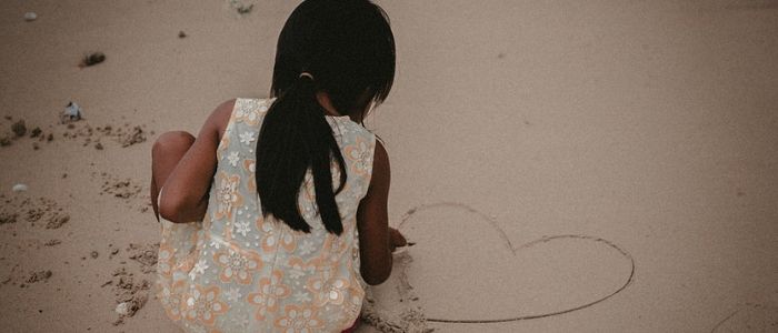 Petite fille dessine sur le sable