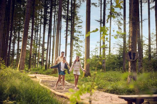 Famille en promenade pieds nus dans la forêt, activité nature et détente à Center Parcs