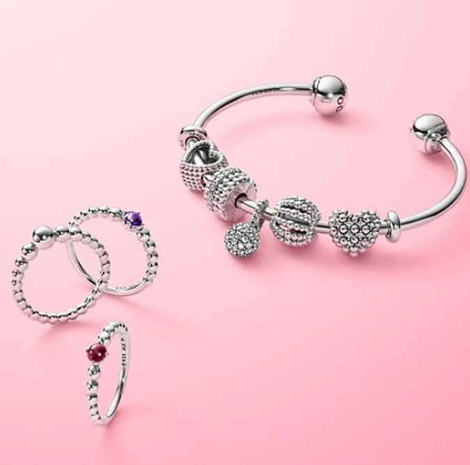 pandora bangle and stacker rings on a pink background